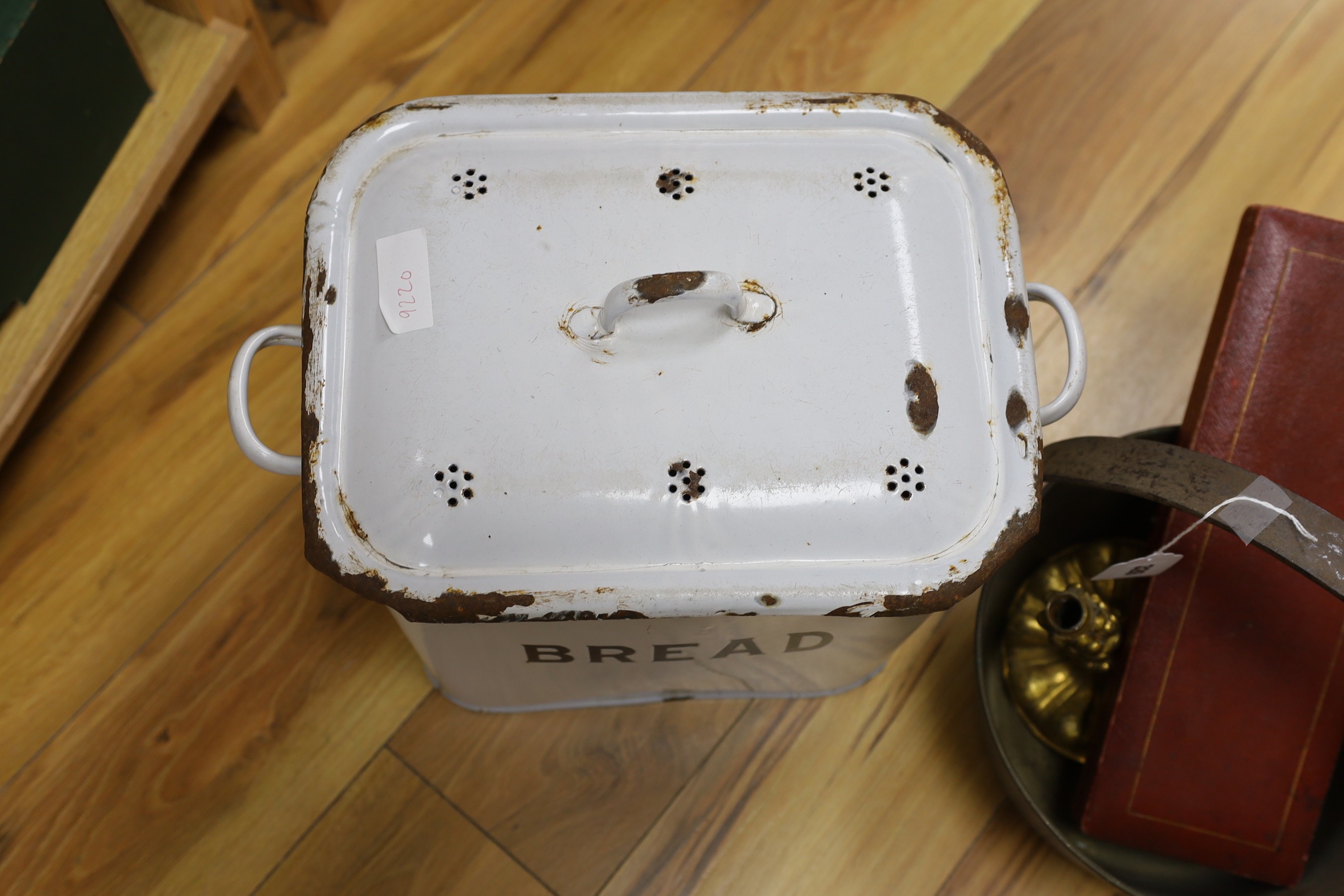 A brass cooking pot, a gilt metal candlestick, an enamel bread bin and cased fish servers